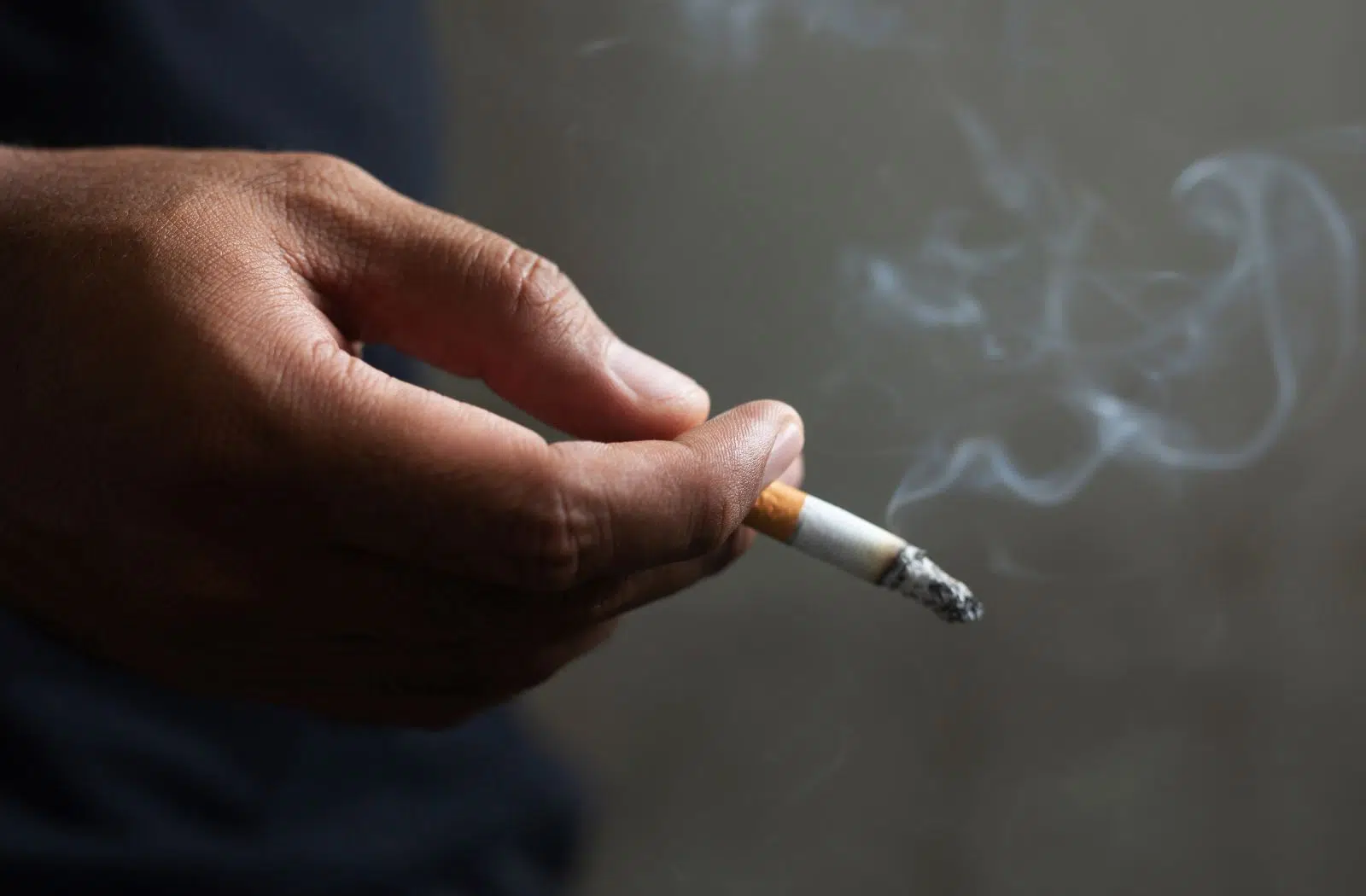 Zigarette in Hand. Vergleich Rauchen und Dampfen.