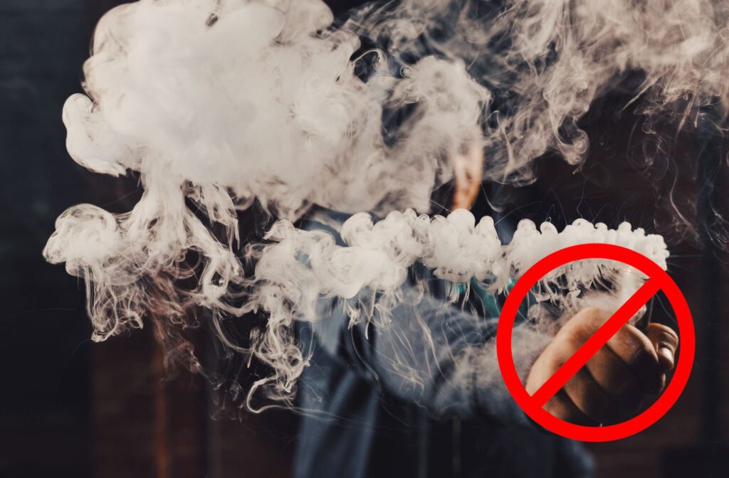 Mann hält eine Vape in der Hand mit viel Rauch